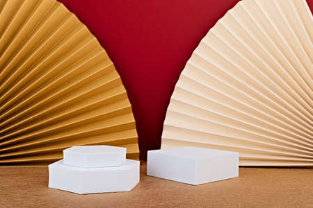 Podium, stand, platform for product presentation.Abstract background made of paper fans and Christmas decoration. Mockup for branding and packaging presentationの写真素材