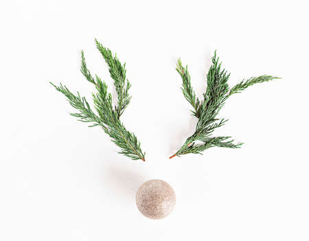 Christmas reindeer concept made of branches and xmas bauble on white background. Minimalist winter seasonal idea. Flat lay, top view compositionの写真素材