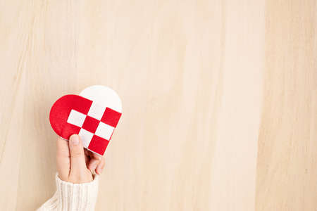 Giving Tuesday concept with woman hands holding red and white heart, charity day concept. Donation, philantropy, help and support idea.  Top view, flat layの写真素材