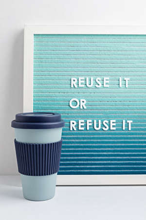 Reusable coffee cup and letterboard with text reuse it or refuse it. Zero waste sustainable lifestyle. Eco friendly habbits for take away coffeeの写真素材