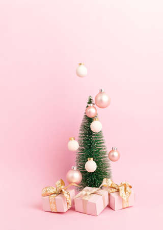Christmas tree with ornaments over pink background. Minimal picture for winter holidays, xmas and new year celebration greeting cardの写真素材
