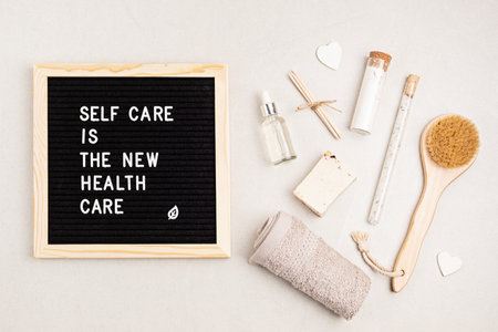 Self care is the new health care. Motivational quote on black letter board with variety of organic body and face care products. Natural homemade eco friendly beauty productsの写真素材
