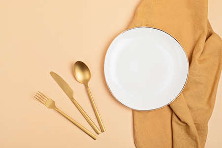 Empty white plate and cotton napkin on pink backdrop. Food background for menu, recipe book. Table...
