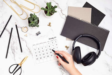 Desktop with calendar for january 2021 and office supplies. home office, social media blog, schedule, planning conceptの写真素材