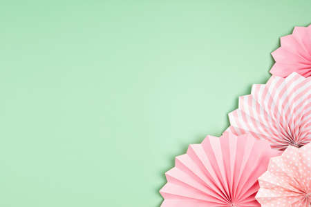 Festive party background with pink paper circle fans over pastel background. Festival, birthday,...