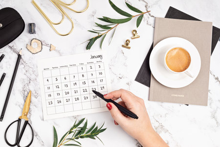 Desktop with calendar for january and office supplies. Home office, social media blog, schedule, planning concept. Flat lay, top viewの写真素材