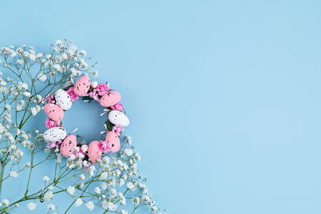 Handmade diy home interior decoration wreath with colorful easter eggs over blue backgroundの写真素材