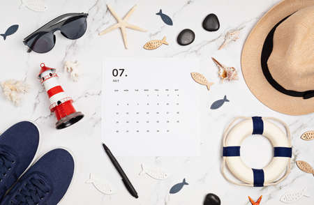 Flat lay with calendar for July with summer holidays fashion accessoriesの写真素材