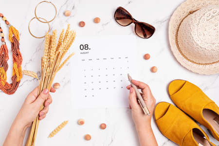 Flat lay with calendar for August with summer holidays fashion accessoriesの写真素材