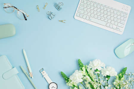 Home office desktop and flowers. Modern workspace with notebook, office stationaryの写真素材