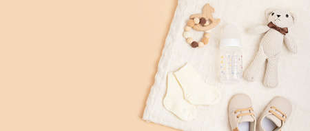 Gender neutral baby shoes and accessories over beige background.の写真素材