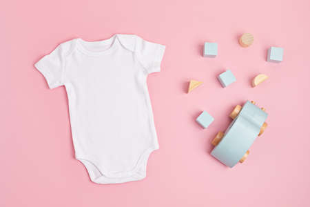 Mockup of white infant bodysuit made of organic cotton with eco friendly baby toysの写真素材