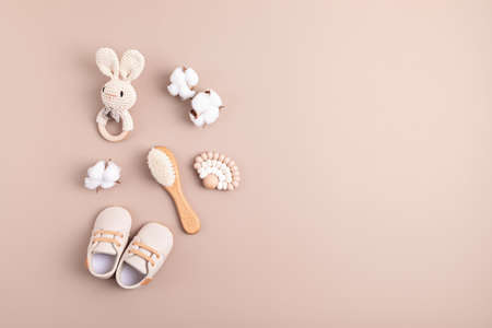 Baby shoes, rattle and teether on neutral background. Organic newborn giftsの写真素材