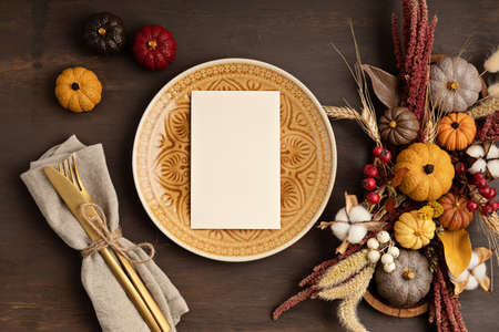 Rustic menu mockup with plate and autumn table decoration. Floral interior decor for fall holidaysの写真素材