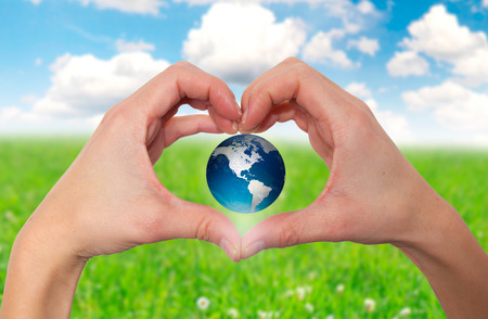 Hands holding green globe with grassy background - Stock Imageの写真素材