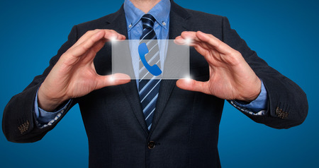 Phonel and contact symbols in front of businessman. Blue background - Stock Imageの写真素材