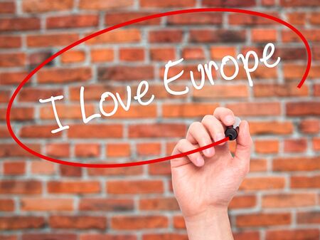 Man Hand writing I Love Europe with black marker on visual screen. Isolated on bricks. Business, technology, internet concept. Stock Photoの写真素材