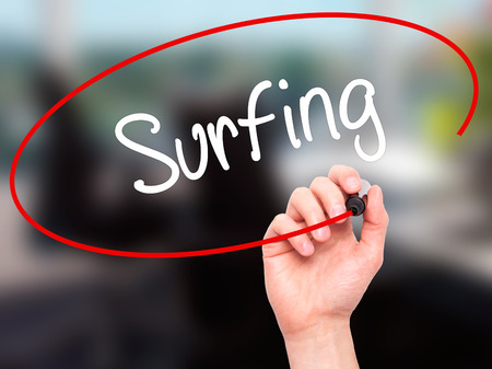 Man Hand writing Surfing  with black marker on visual screen. Isolated on office. Business, technology, internet concept. Stock Photoの写真素材
