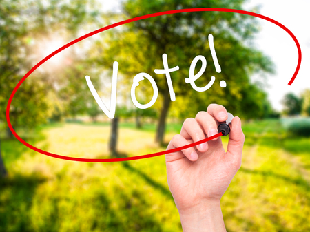Man Hand writing Vote! with black marker on visual screen. Isolated on nature. Business, technology, internet concept. Stock Photoの写真素材