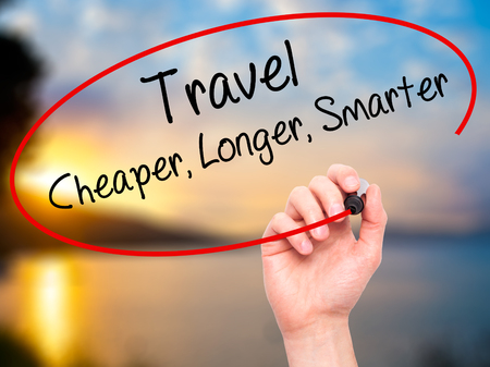 Man Hand writing Travel Cheaper Longer Smarter  with black marker on visual screen. Isolated on nature. Business, technology, internet concept. Stock Photoの写真素材