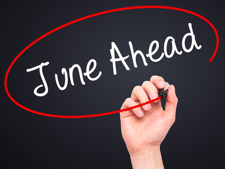 Man Hand writing June Ahead with black marker on visual screen. Isolated on black. Business, technology, internet concept. Stock Photoの写真素材
