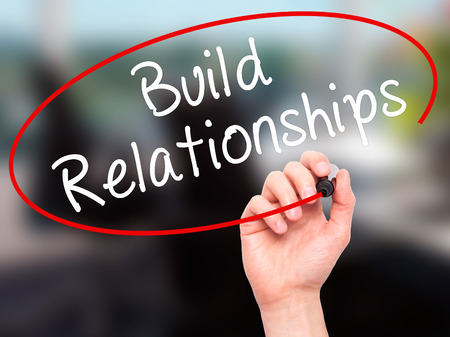 Man Hand writing Build Relationships with black marker on visual screen. Isolated on office. Business, technology, internet concept. Stock Imageの写真素材