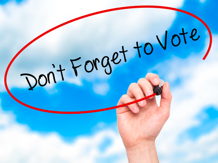 Man Hand writing Don't Forget to Vote with black marker on visual screen. Isolated on sky. Business, technology, internet concept. Stock Photoの写真素材