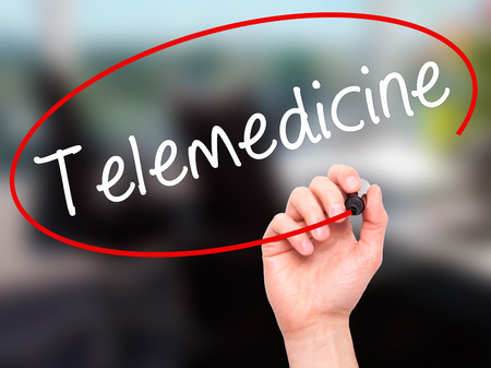 Man Hand writing Telemedicine with black marker on visual screen. Isolated on office. Business, technology, internet concept. Stock Imageの写真素材