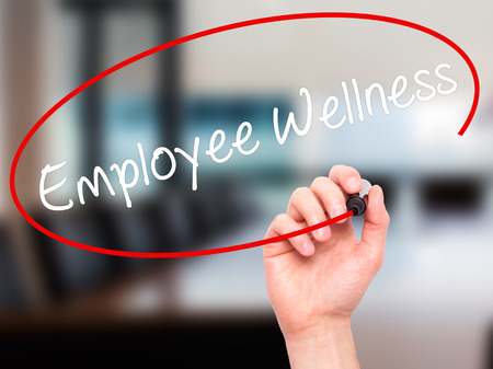 Man Hand writing Employee Wellness with black marker on visual screen. Isolated on background. Business, technology, internet concept. Stock Photoの写真素材