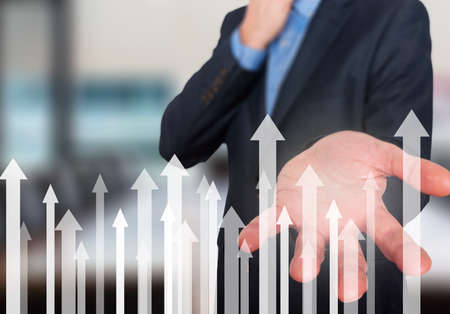 Businessman with financial symbols coming. Business, growth, investment concept. Man hand showing arrows. Isolated on office. Stock Imageの写真素材