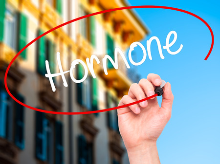 Man Hand writing Hormone with black marker on visual screen. Isolated on background. Business, technology, internet concept. Stock Photoの写真素材