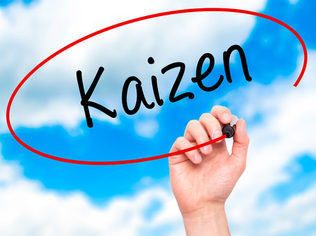 Man Hand writing Kaizen with black marker on visual screen. Isolated on sky. Business, technology, internet concept. Stock Photoの写真素材