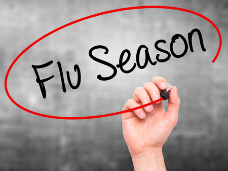 Man Hand writing  Flu Season with black marker on visual screen. Isolated on background. Business, technology, internet concept. Stock Photoの写真素材
