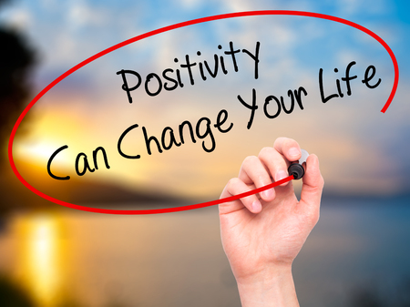 Man Hand writing Positivity Can Change Your Life with black marker on visual screen. Isolated on background. Business, technology, internet concept. Stock Photoの写真素材