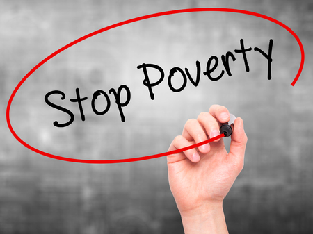 Man Hand writing Stop Poverty  with black marker on visual screen. Isolated on background. Business, technology, internet concept. Stock Photoの写真素材