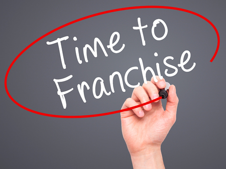 Man Hand writing Time to Franchise with black marker on visual screen. Isolated on grey. Business, technology, internet concept. Stock Photo Man Hand writing Time to Franchise with black marker on visual screen. Isolated on grey. Business, technology, internet concept. Stock Photo