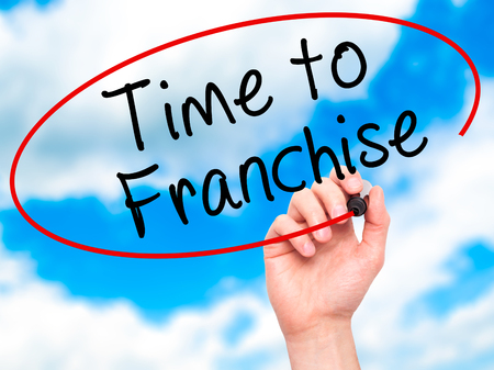 Man Hand writing Time to Franchise with black marker on visual screen. Isolated on sky. Business, technology, internet concept. Stock Photo Man Hand writing Time to Franchise with black marker on visual screen. Isolated on sky. Business, technology, internet concept. Stock Photo