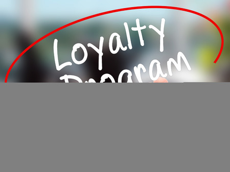 Man Hand writing Loyalty Program with black marker on visual screen. Isolated on office. Business,...