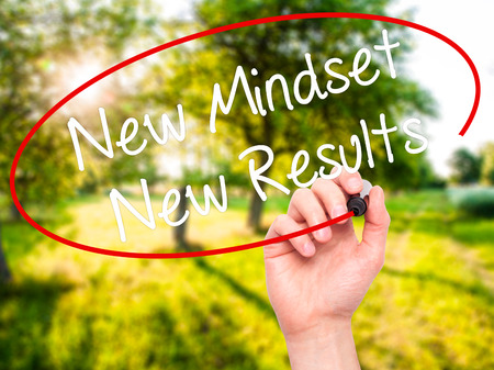 Man Hand writing New Mindset New Results with black marker on visual screen. Isolated on nature. Business, technology, internet concept. Stock Photoの写真素材