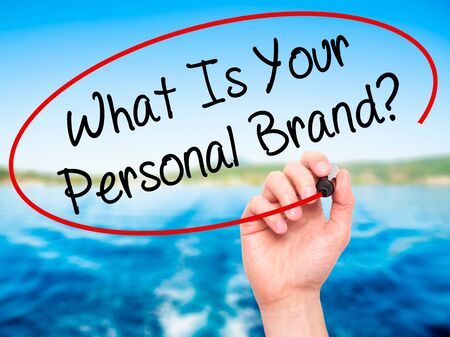 Man Hand writing What Is Your Personal Brand? with black marker on visual screen. Isolated on nature. Business, technology, internet concept. Stock Photoの写真素材