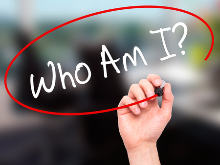 Man Hand writing Who Am I? with black marker on visual screen. Isolated on office. Business, technology, internet concept. Stock Photoの写真素材