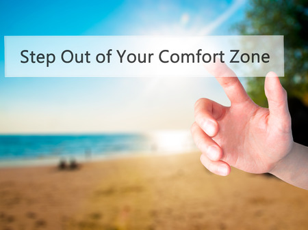 Step Out of Your Comfort Zone - Hand pressing a button on blurred background concept . Business, technology, internet concept. Stock Photoの写真素材