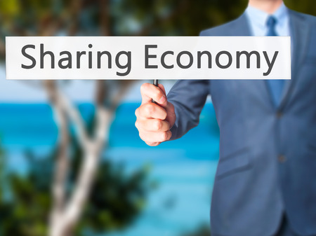 Sharing Economy - Businessman hand holding sign.の写真素材