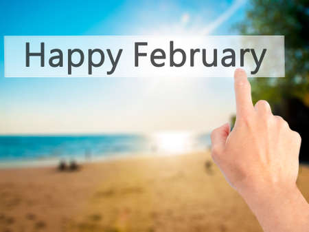 Happy February - Hand pressing a button on blurred background concept . Business, technology, internet concept. Stock Photoの写真素材