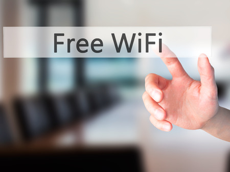 Free WiFi  - Hand pressing a button on blurred background concept . Business, technology, internet concept. Stock Photoの写真素材