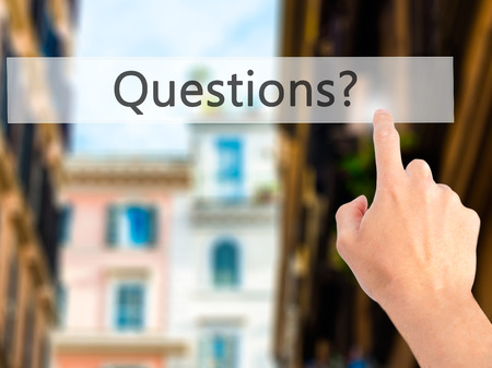Questions ? - Hand pressing a button on blurred background concept . Business, technology, internet concept. Stock Photoの写真素材