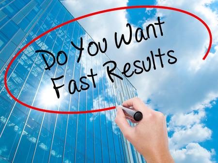 Man Hand writing Do You Want Fast Results with black marker on visual screen.  Business, technology, internet concept. Modern business skyscrapers background. Stock Photoの写真素材