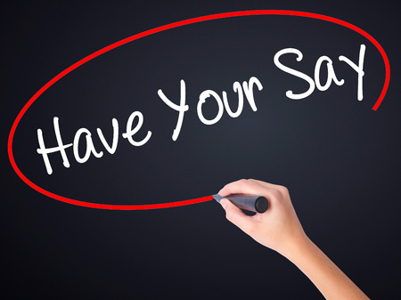 Woman Hand Writing Have Your Say on blank transparent board with a marker isolated over black background. Business concept. Stock Photoの写真素材