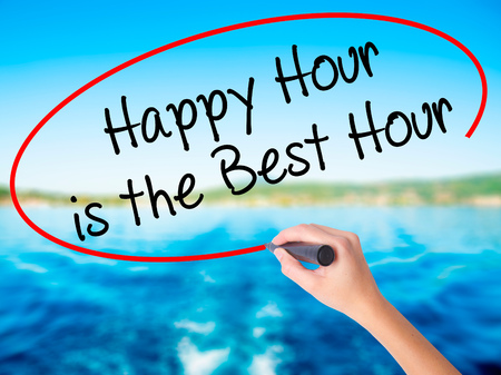 Woman Hand Writing Happy Hour is the Best Hour  on blank transparent board with a marker isolated over water background. Business concept. Stock Photoの写真素材