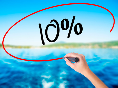 Woman Hand Writing 10%  on blank transparent board with a marker isolated over water background. Business concept. Stock Photoの写真素材